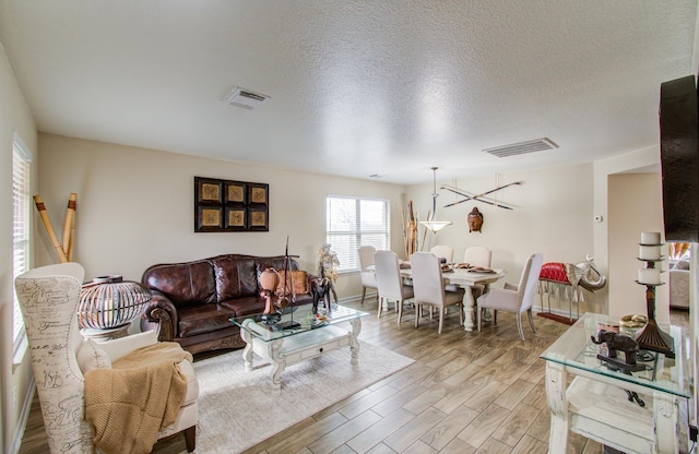 living room with light hardwood / wood-style flooring and a textured ceiling