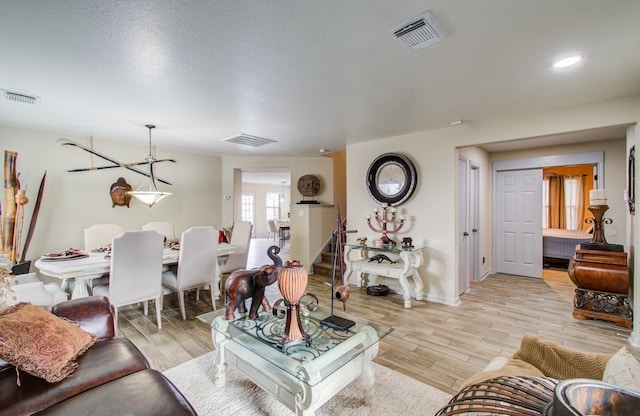 living room with light wood-type flooring and a textured ceiling