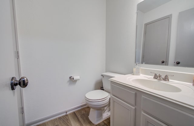 bathroom featuring toilet, hardwood / wood-style flooring, and vanity