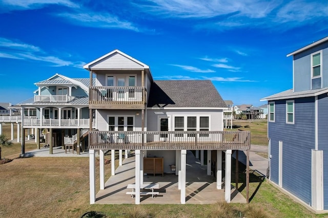 rear view of property with a patio, a balcony, and a lawn