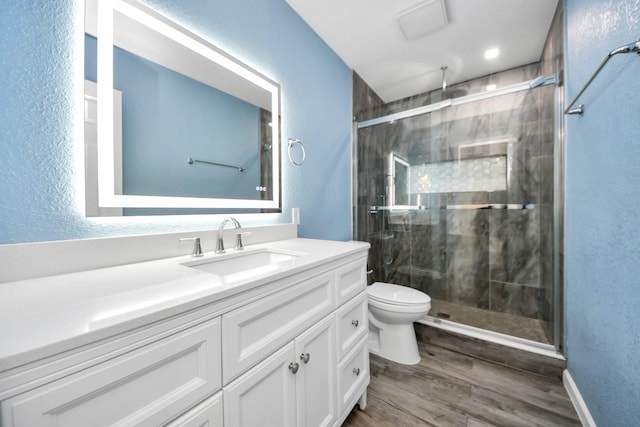 bathroom featuring toilet, walk in shower, hardwood / wood-style floors, and vanity