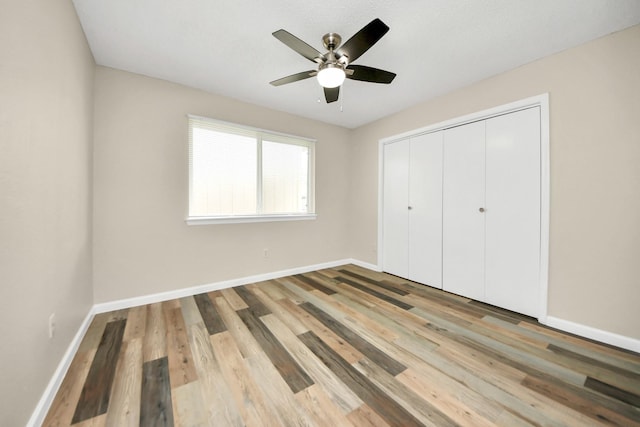 unfurnished bedroom with ceiling fan, a closet, and light hardwood / wood-style floors