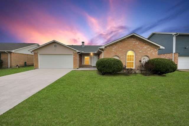 single story home featuring a lawn and a garage