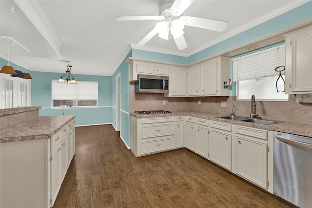 kitchen with dark wood-style flooring, crown molding, stainless steel appliances, decorative backsplash, and a sink