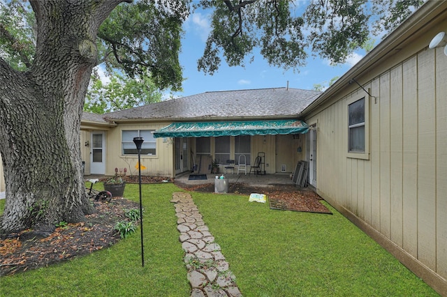 back of property featuring a patio and a lawn