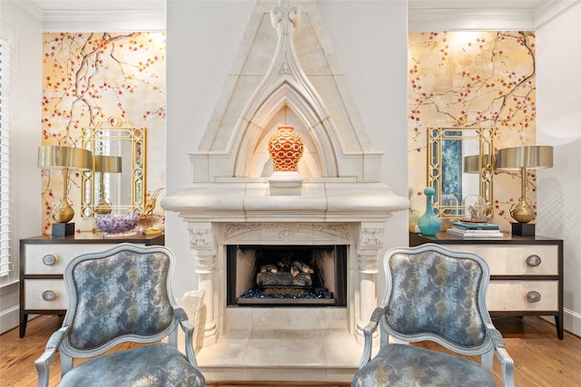 living area featuring a fireplace, ornamental molding, and wood-type flooring