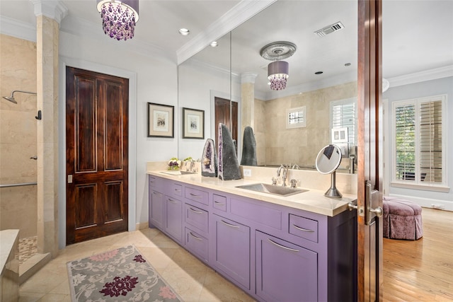 bathroom with decorative columns, ornamental molding, vanity, and walk in shower