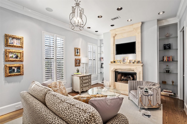 living room featuring hardwood / wood-style flooring, crown molding, and a high end fireplace