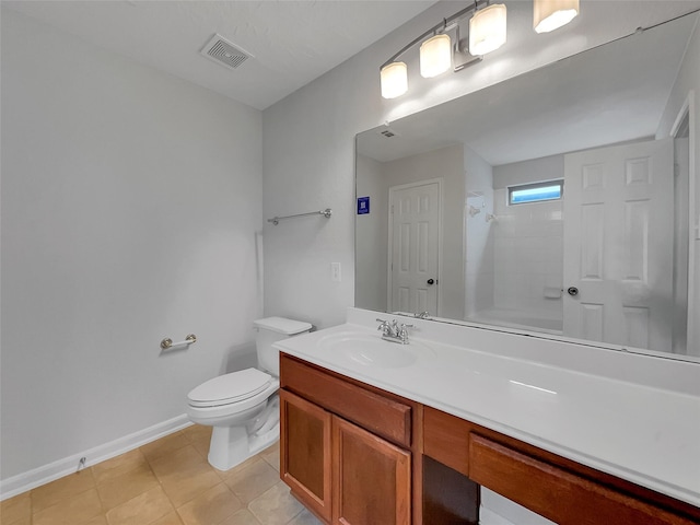 bathroom with toilet, vanity, and tile patterned flooring