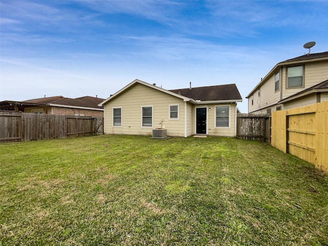 rear view of house featuring a yard and central AC unit