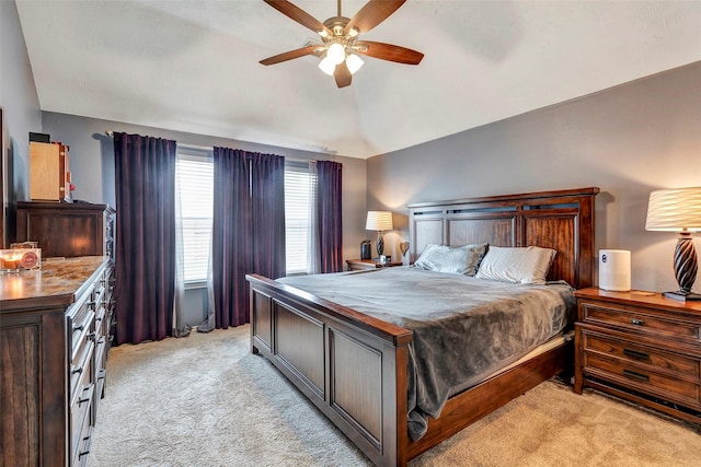 bedroom with vaulted ceiling, a ceiling fan, and light colored carpet