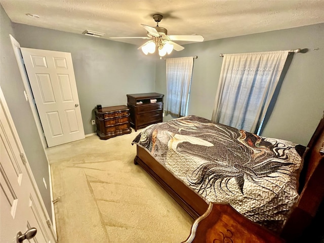 bedroom with carpet, visible vents, and a ceiling fan