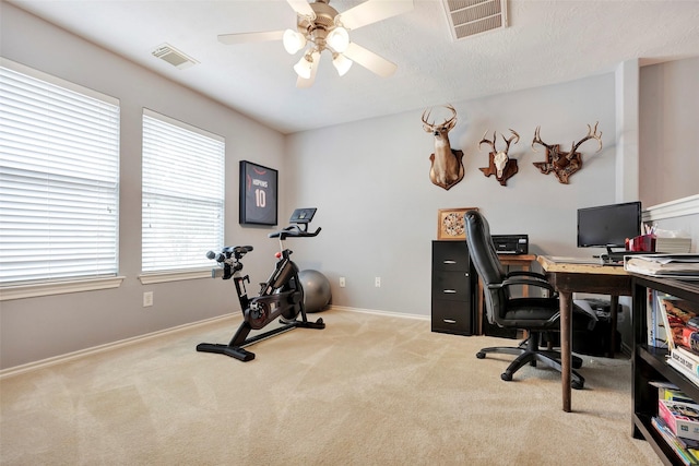 home office with a ceiling fan, baseboards, visible vents, and carpet flooring