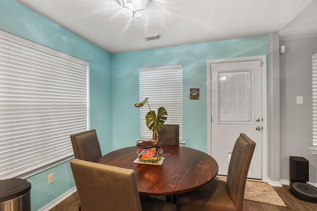 dining room with visible vents, baseboards, and wood finished floors