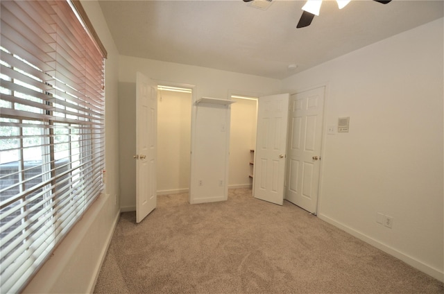 unfurnished bedroom featuring light colored carpet and ceiling fan