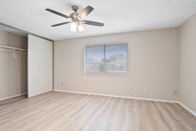 unfurnished bedroom with ceiling fan, light hardwood / wood-style floors, a textured ceiling, and a closet