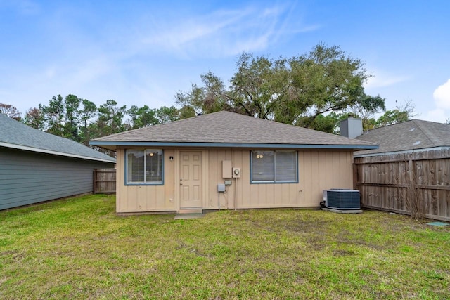 rear view of property featuring a yard and central AC