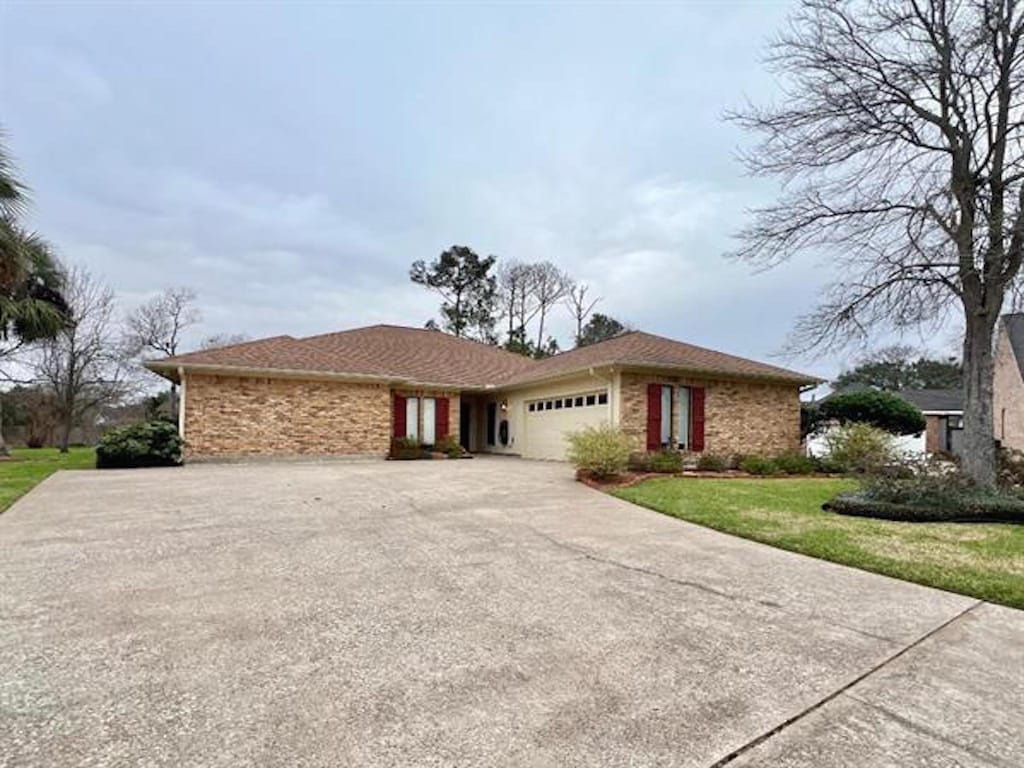 single story home with a garage and a front yard