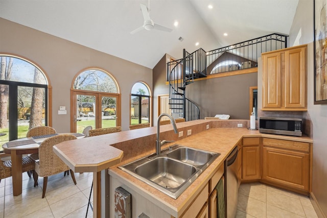 kitchen featuring ceiling fan, stainless steel appliances, a sink, and light countertops