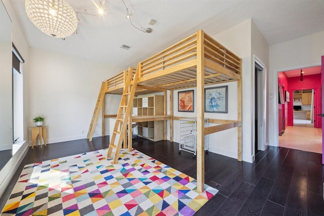 bedroom featuring dark wood-style floors, visible vents, and baseboards