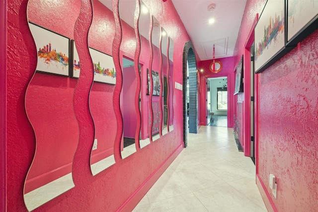 corridor featuring attic access and a textured wall