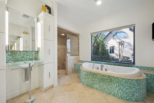 full bath featuring visible vents, a bath, backsplash, tile patterned flooring, and a sink