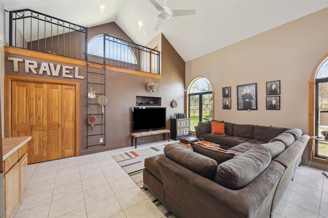 living area with light tile patterned floors, high vaulted ceiling, and a ceiling fan