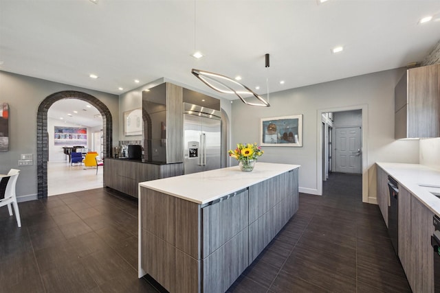 kitchen featuring a spacious island, modern cabinets, light countertops, and decorative light fixtures