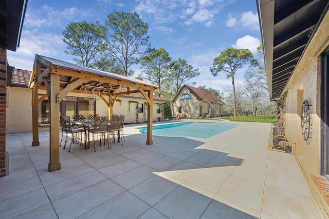 pool with an outdoor structure, outdoor dining area, a patio, and a gazebo