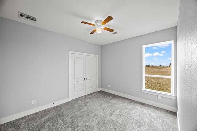 unfurnished bedroom featuring a closet, carpet flooring, and ceiling fan