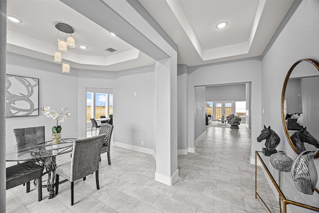 dining area featuring a tray ceiling and a healthy amount of sunlight