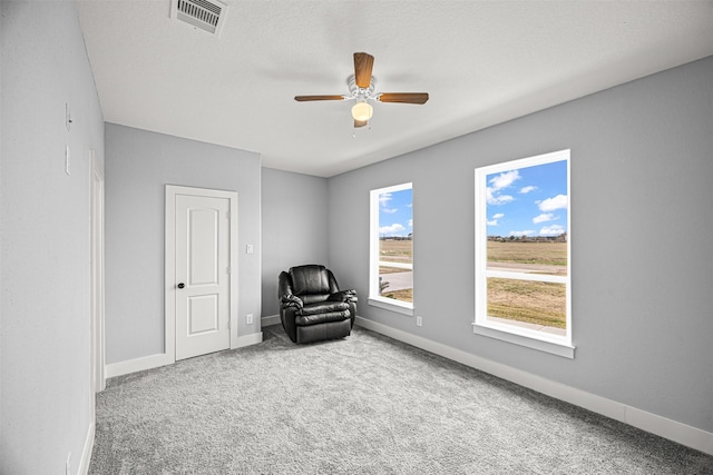 unfurnished room with ceiling fan, carpet, and a textured ceiling