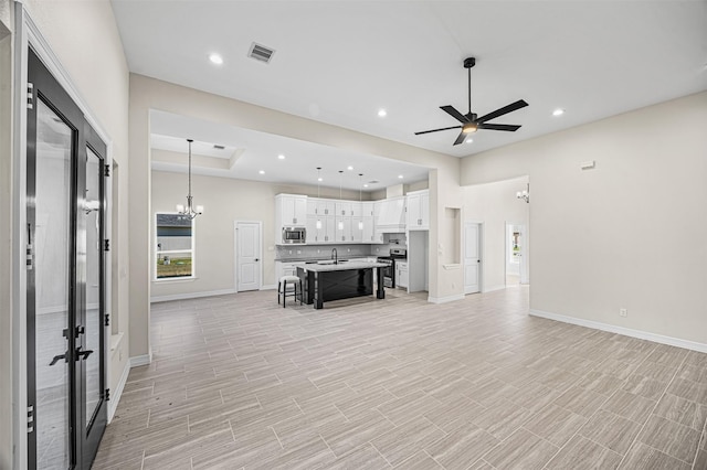 living room with sink and ceiling fan with notable chandelier