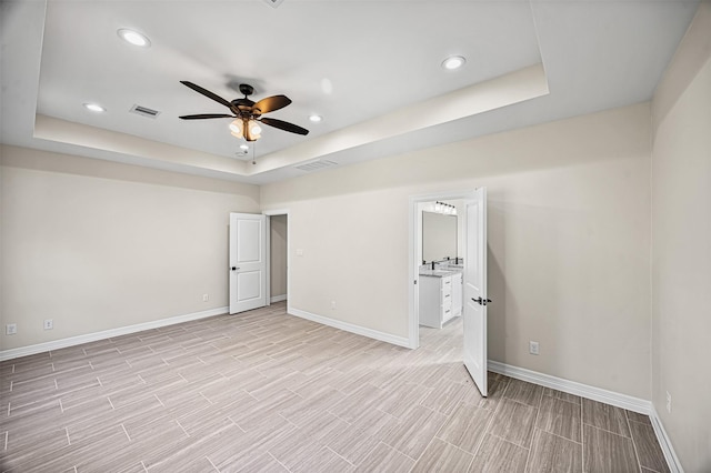 unfurnished bedroom with a raised ceiling and ceiling fan