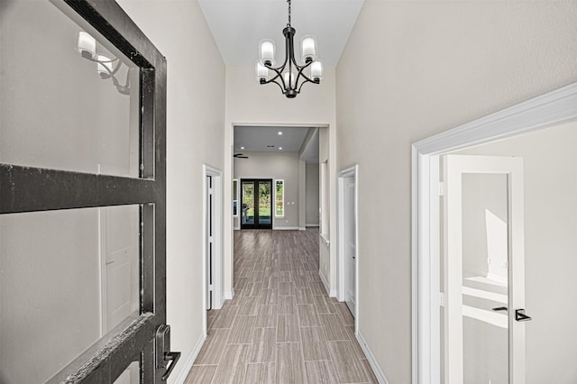 hall featuring high vaulted ceiling and a notable chandelier