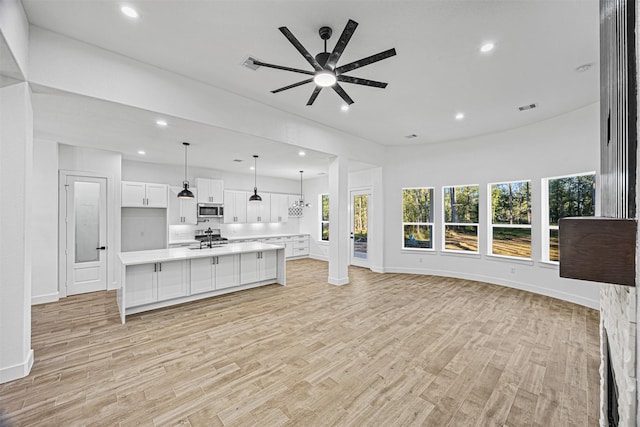 unfurnished living room featuring light wood-type flooring and ceiling fan