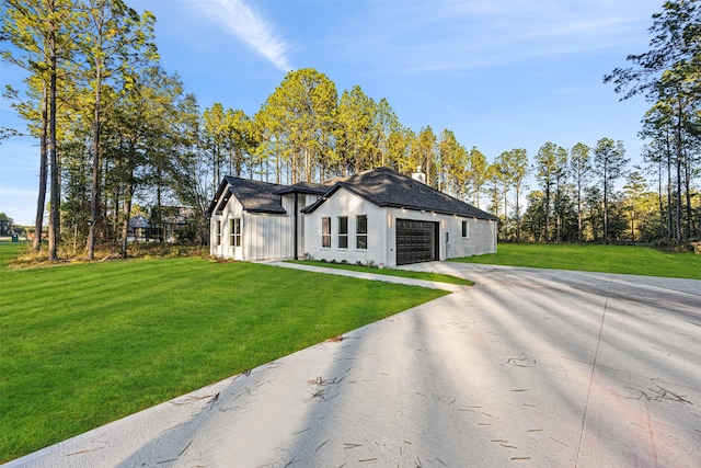 modern inspired farmhouse featuring a garage, concrete driveway, a front lawn, board and batten siding, and a chimney