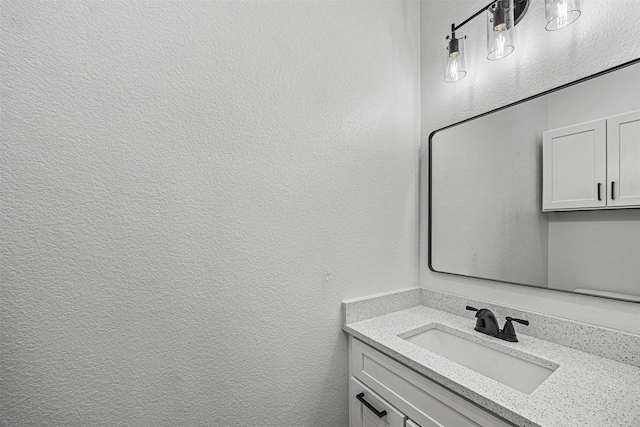 bathroom featuring a textured wall and vanity