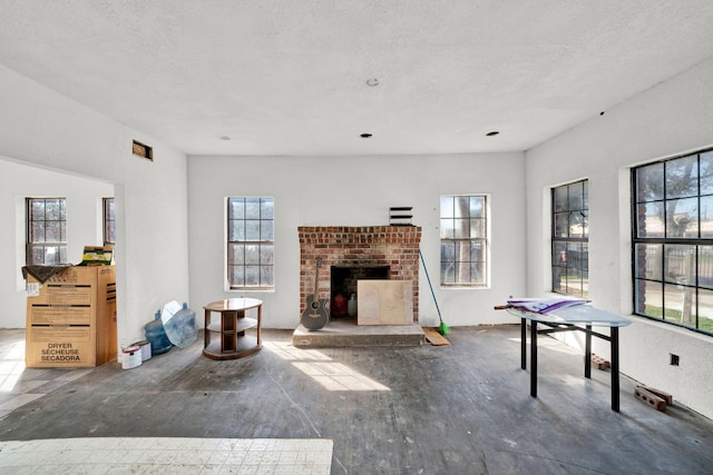 recreation room featuring a fireplace and a textured ceiling