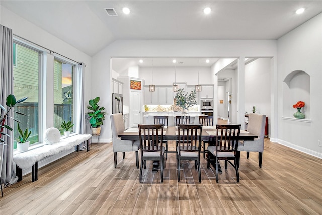 dining space featuring light hardwood / wood-style floors and lofted ceiling