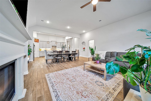 living room with light hardwood / wood-style flooring and ceiling fan