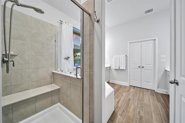 bathroom with hardwood / wood-style floors, an enclosed shower, and vanity