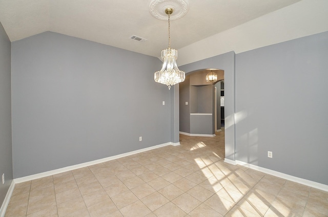 empty room featuring a chandelier, arched walkways, lofted ceiling, and baseboards