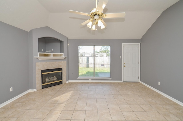 unfurnished living room featuring lofted ceiling, baseboards, a tiled fireplace, and light tile patterned flooring