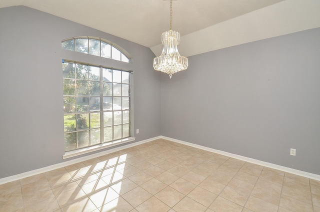 spare room featuring a chandelier, light tile patterned flooring, vaulted ceiling, and baseboards