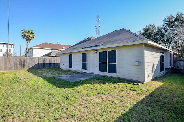 back of house featuring a fenced backyard, a yard, and a patio