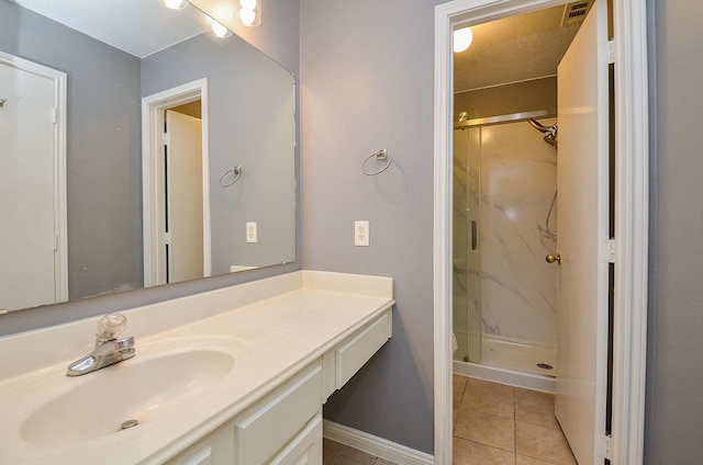 bathroom with visible vents, tile patterned flooring, a marble finish shower, and vanity