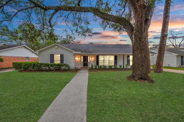 ranch-style home with a yard