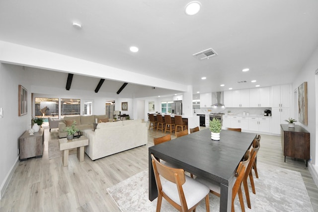 dining area featuring light hardwood / wood-style floors and beam ceiling