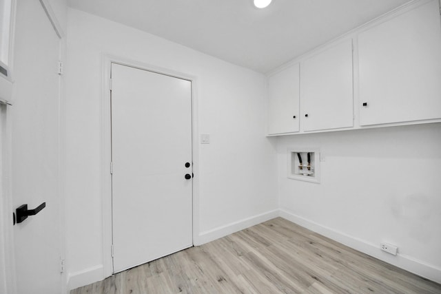 clothes washing area featuring light wood-type flooring, cabinets, and washer hookup